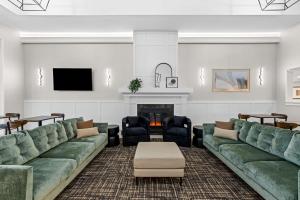 a living room with green couches and a fireplace at Best Western Plus Puyallup Hotel in Puyallup