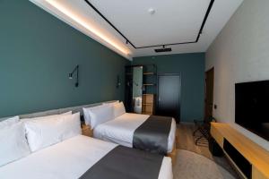 乔治敦Aiden by Best Western Georgetown Guyana的一间有两张床和一台平板电视的酒店房间