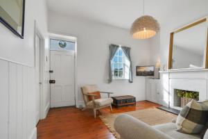 salon z kominkiem i krzesłem w obiekcie Prues Cottage w mieście Port Fairy +13 zdjęć