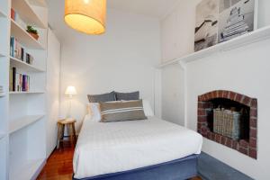 niewielka sypialnia z łóżkiem i kominkiem w obiekcie Prues Cottage w mieście Port Fairy