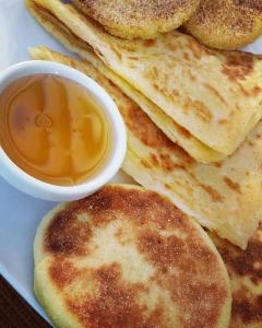 a plate of pancakes with a bowl of dipping sauce at Hôtel Riad Atlas Dades in Boumalne