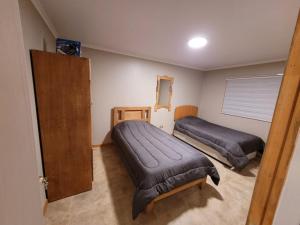 a bedroom with two beds and a door in it at Estancia Don Beto in Pan de Azúcar