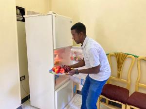 a man standing in front of an open refrigerator at La Veranda 陽台 in Aswan