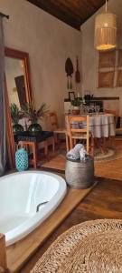 a large bath tub in a room with a table at Chalé Pétala - Vila Monte Cunha in Cunha