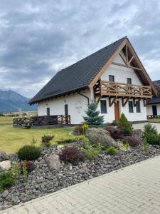 a small white house with a gambrel roof at Villa Štít Stará Lesná in Stará Lesná