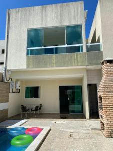 ein Haus mit drei Frisbees vor einem Swimmingpool in der Unterkunft Casa Da Onda in Tamandaré