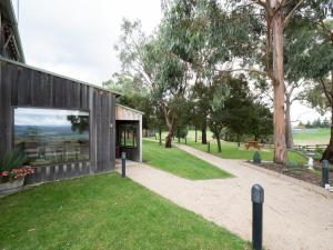 a house with a glass door on a grass field at Bundaleera Vineyard and Farm Stay in Relbia