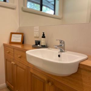 a bathroom with a white sink on a wooden counter at Bundaleera Vineyard and Farm Stay in Relbia +14 photos