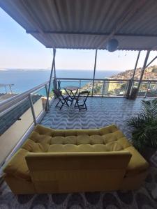 a couch on a balcony with a view of the ocean at Casa de Férias Carioca in Rio de Janeiro