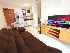 Una sala de estar con un sofá y un televisor de pantalla plana. en Intermares, Apartamento Automatizado e Inteligente - Piscina, Elevador, Garagem - Conforto, Paz e Sossego, excelente para descansar, trabalhar ou estudar, en Cabedelo