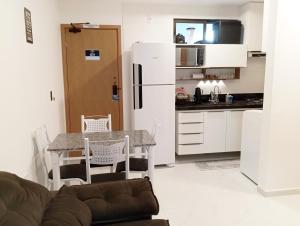 Una sala de estar con una mesa y una cocina. en Intermares, Apartamento Automatizado e Inteligente - Piscina, Elevador, Garagem - Conforto, Paz e Sossego, excelente para descansar, trabalhar ou estudar, en Cabedelo