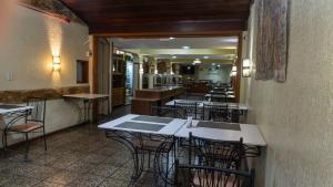 a restaurant with tables and chairs in a room at Canoas Hotel Castel in Canoas