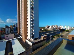 Vista de un edificio alto con una ciudad al fondo. en Intermares, Apartamento Automatizado e Inteligente - Piscina, Elevador, Garagem - Conforto, Paz e Sossego, excelente para descansar, trabalhar ou estudar, en Cabedelo