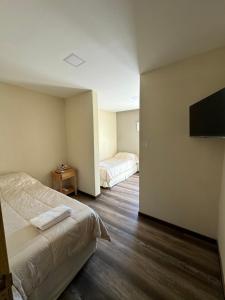 a bedroom with two beds and a flat screen tv at Florida 55 in Salta