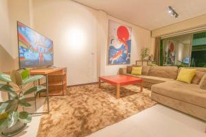a living room with a couch and a flat screen tv at The Town House in Pai