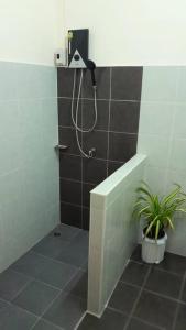 a bathroom with a shower with a plant in it at The Town House in Pai