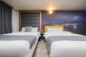 Postel nebo postele na pokoji v ubytování Sokcho Ritz Hotel