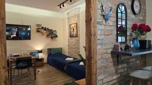 a living room with a couch and a brick wall at Magiczne Mieszkanko in Piła