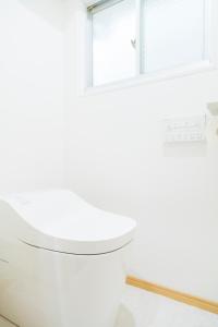 a white toilet in a bathroom with a window at 貸切戸建て3beds Private House Sleep Man in Kagoshima