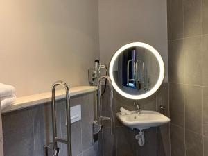 un baño con lavabo y espejo en Peaceful Antoing Bungalow, en Antoing 32 fotos más