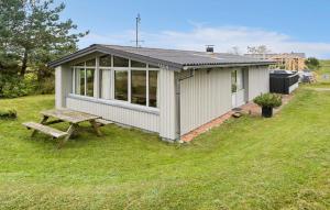 a small shed with a picnic table in the grass at 2 Bedroom Stunning Home In Rømø in Lakolk +14 photos