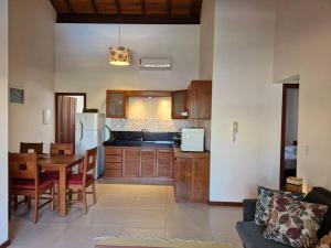 una cucina e una sala da pranzo con tavolo e cucina di Apartamento tranquilo elegante espaçoso a Porto Seguro