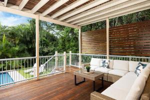 a screened in porch with a couch and a table at Large Family Pool Home in Taringa 6km to CBD Pets in Brisbane