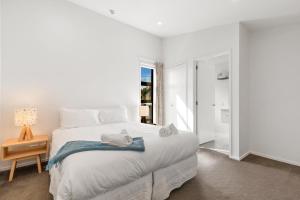 Un dormitorio blanco con una cama con toallas. en Tenby Apartments, en Wanaka