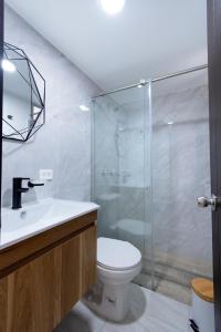 a bathroom with a toilet and a glass shower at apartamento encantador cerca del centro in Santa Rosa de Cabal