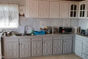 a kitchen with white cabinets and a sink at Windsor Apartment in Kingstown