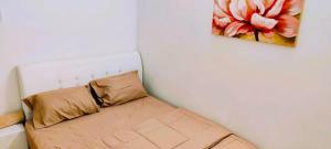 a bed in a room with a painting on the wall at Cozy Homestay in Ipoh