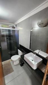 a bathroom with a toilet and a sink at 2qts, 2 AR, 3 TV, Perto da Praia, Garagem in Itaparica