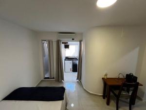 Un dormitorio con una cama, un escritorio y una mesa. en Flat completo para até 4 pessoas no Vidigal - RJ, en Río de Janeiro