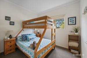 a bedroom with a bunk bed with a ladder at Red Rocks Beach Retreat Cowes Phillip Island in Cowes