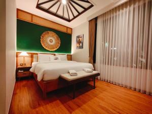 a bedroom with a bed and a table and a window at Rabasta Enjoy Kuta in Denpasar
