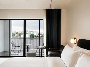 ein Hotelzimmer mit Bett und Balkon in der Unterkunft The StandardX, Bangkok Phra Arthit in Bangkok