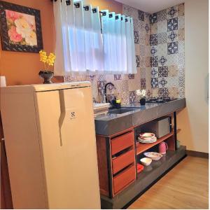 a kitchen with a refrigerator and a sink at Perfeito Studio 22 in Poços de Caldas