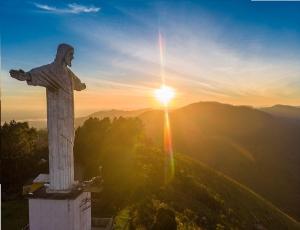 a statue of a christ the redeemer at sunset at Perfeito Studio 22 in Poços de Caldas