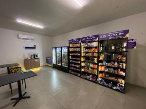 a store aisle with shelves of food and drinks at Charmoso Flat na Serra - Granja Brasil Itaipava in Itaipava