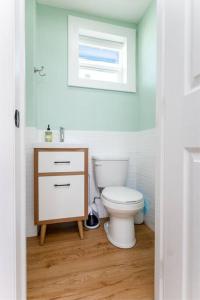 ein Badezimmer mit einer weißen Toilette und einem Waschbecken in der Unterkunft Be A Nomad - Beach Cottage Oceanfront in Jacksonville Beach