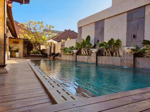 a swimming pool in the middle of a house at Rabasta Enjoy Kuta in Kuta
