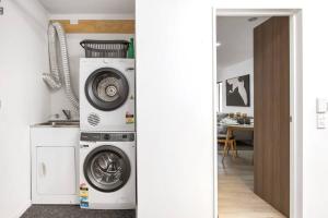 un lavadero con lavadora y secadora en Convenient Urban Townhouse 2 carparks available, en Christchurch