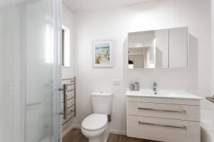Un baño blanco con inodoro y lavabo. en Convenient Urban Townhouse 2 carparks available, en Christchurch 13 fotos más
