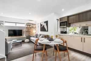 Una cocina y una sala de estar con mesa y sillas. en Convenient Urban Townhouse 2 carparks available, en Christchurch