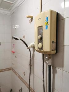 a shower in a bathroom with a dispenser on the wall at API API APARTMENT HOMESTAY BESIDE CENTRE POINT 1BR 3Pax in Kota Kinabalu
