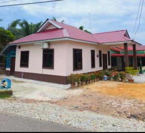 a house with a red roof and some plants at Homestay Merah Jambu UTHM in Parit Raja