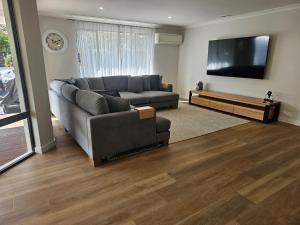 a living room with a couch and a flat screen tv at Seadrift House - Quindalup in Quindalup