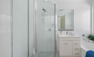 a white bathroom with a shower and a sink at Azul Blue at Shellys in Port Macquarie +11 photos