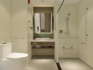 a bathroom with a toilet and a sink and a mirror at Holiday Inn Express Xi'an Daxing by IHG in Xi'an