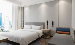 a bedroom with a large white bed and a chair at Holiday Inn Express Xi'an Daxing by IHG in Xi'an